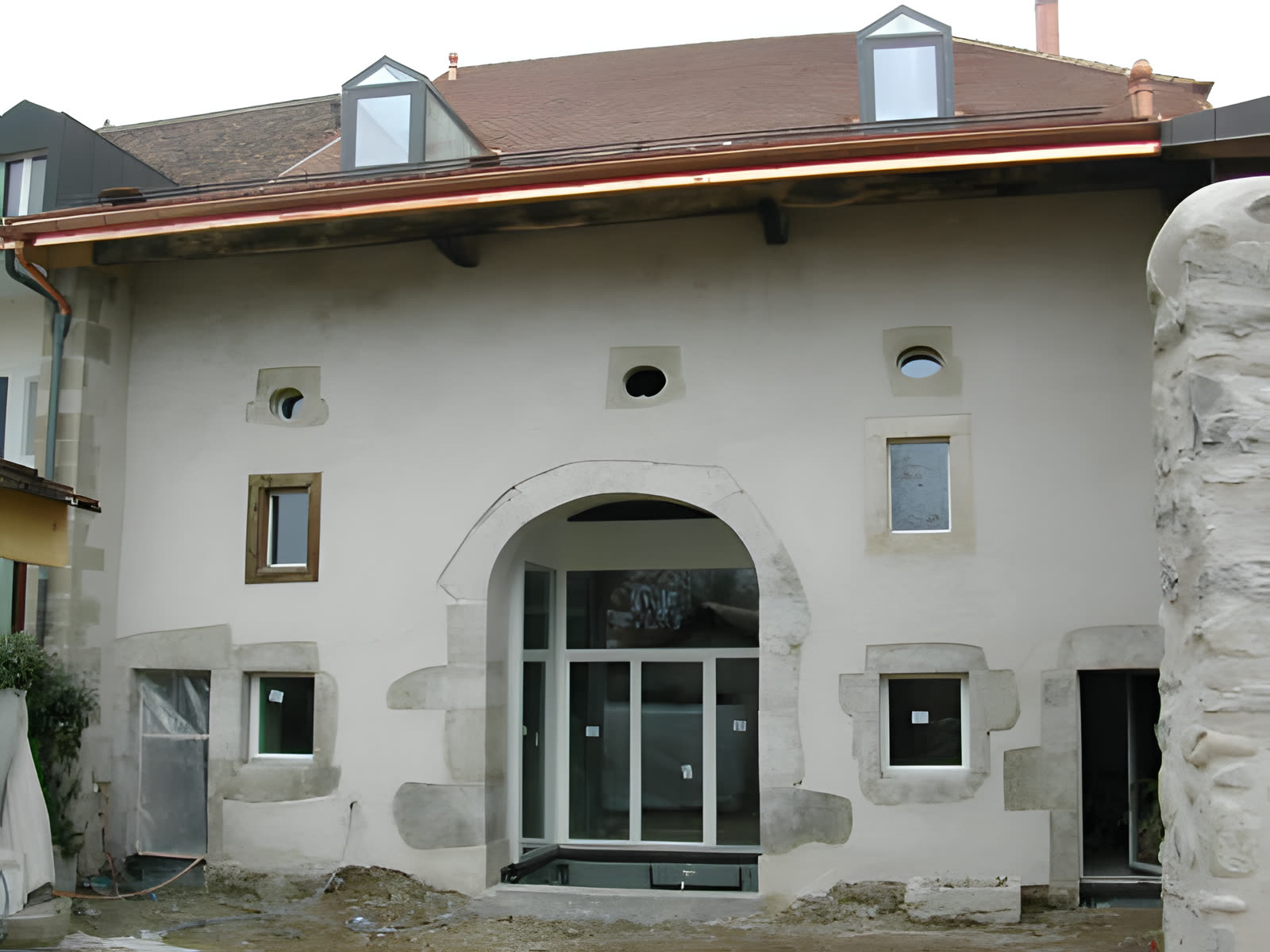 Bâtiment ancien rénové avec grande baie en arc